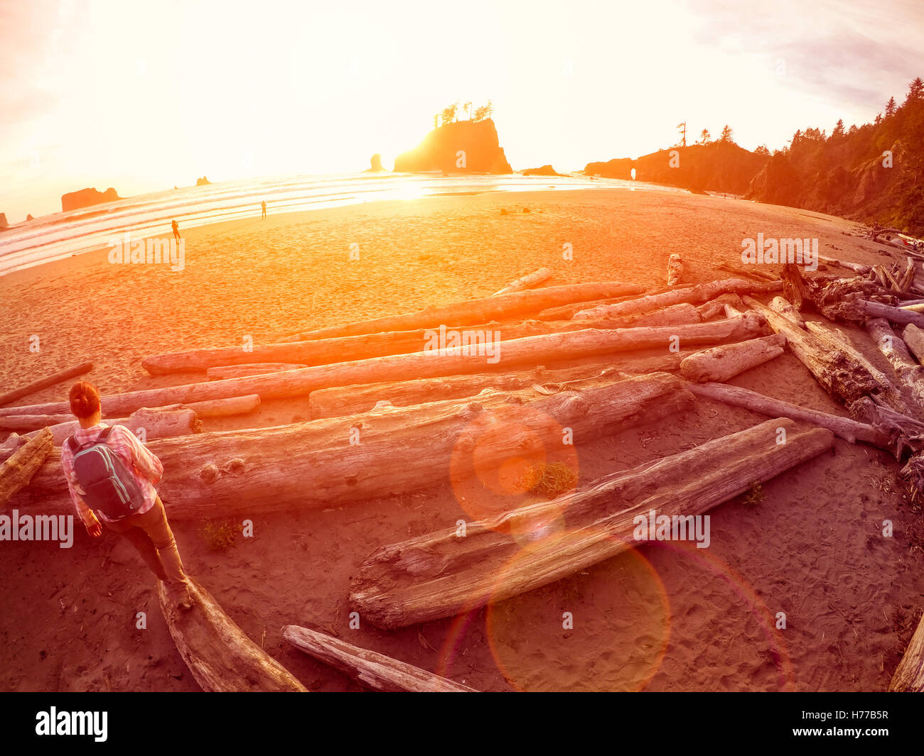 Woman standing on a log on beach, La plush, Washington, United States Stock Photo