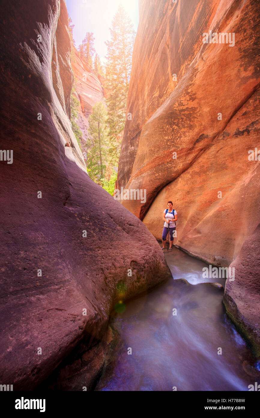 Woman walking through red slot canyon, Utah, United States Stock Photo