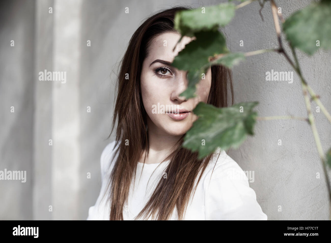 Portrait of a woman with face obscured by leaves Stock Photo