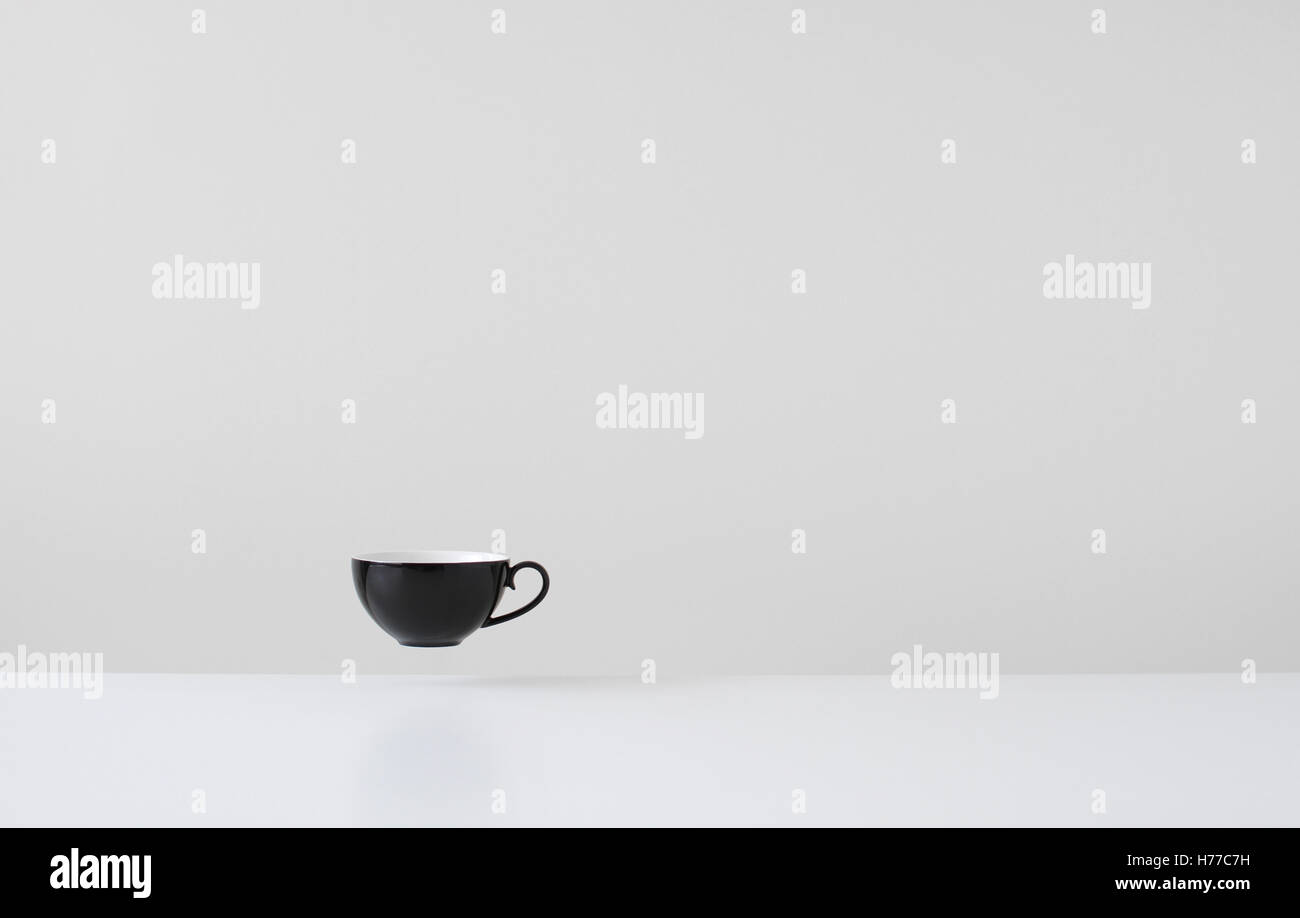 Black coffee cup floating mid air Stock Photo