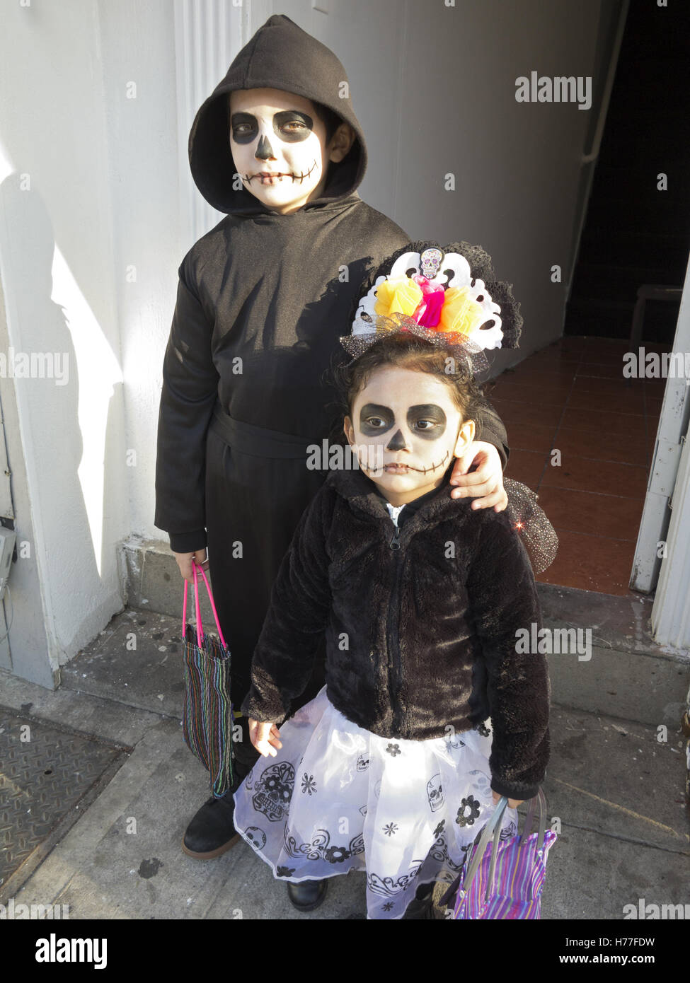 Mexican siblings wear Day of the Dead costumes on Halloween in the Bensonhurst section of Brooklyn, New York, 2016. Stock Photo