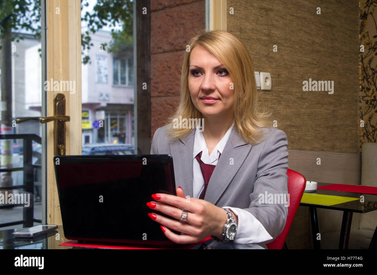 blonde woman in cafe with laptop Stock Photo - Alamy