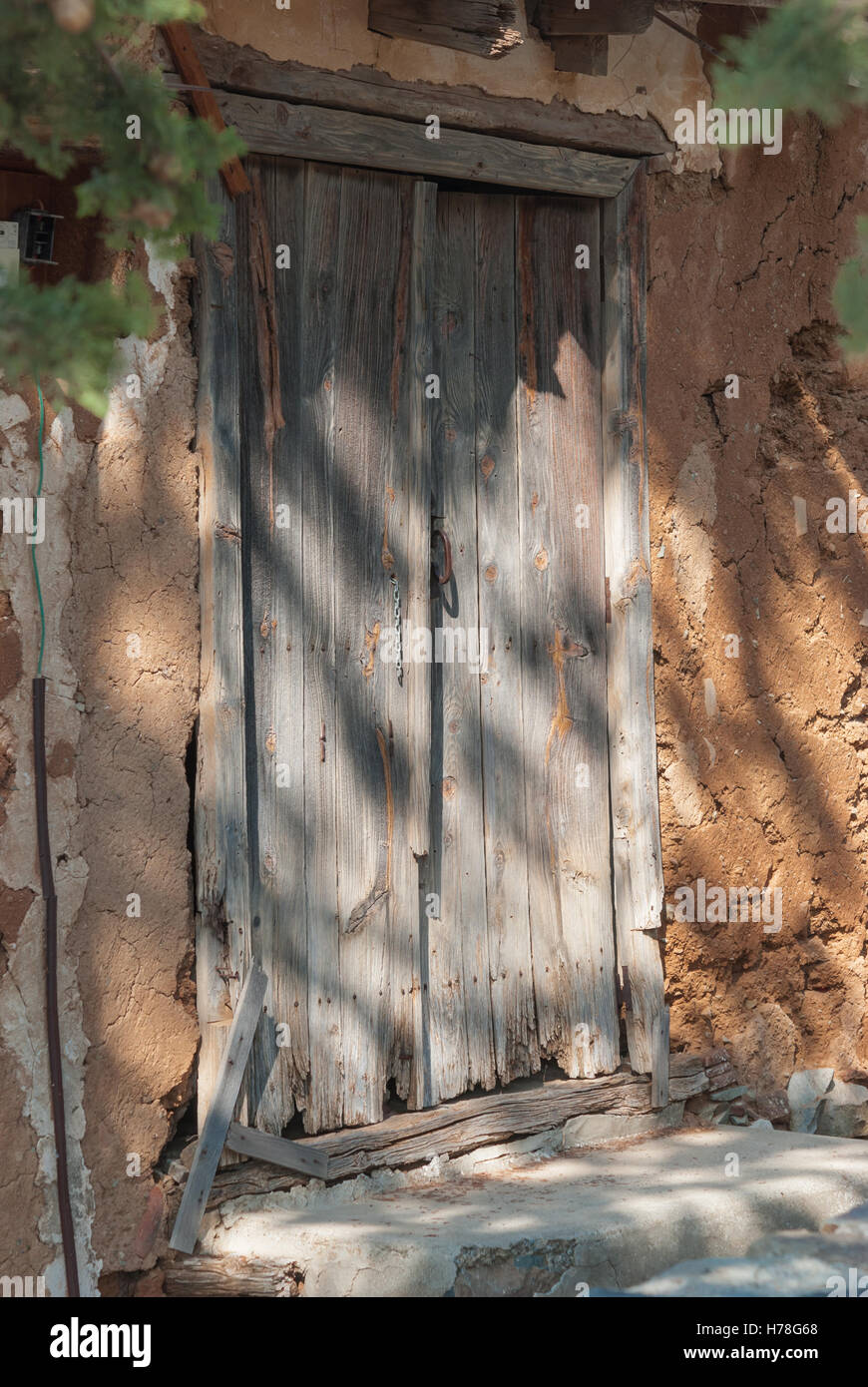 Old blue shabby wooden door with rusty hinges at the entrance of old ...