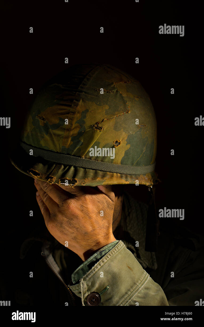 American soldier from the Vietnam War period, with his hands covering