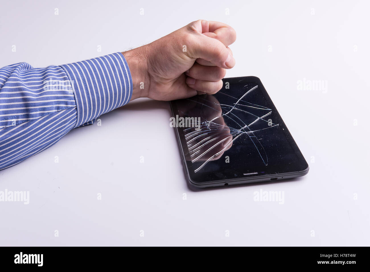 A fist breaks a tablet Stock Photo