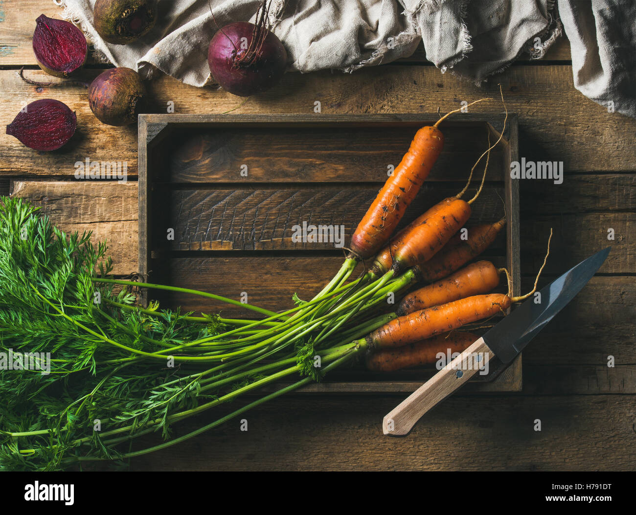 Fresh carrots and beetroots in wooden tray over rustic background Stock Photo