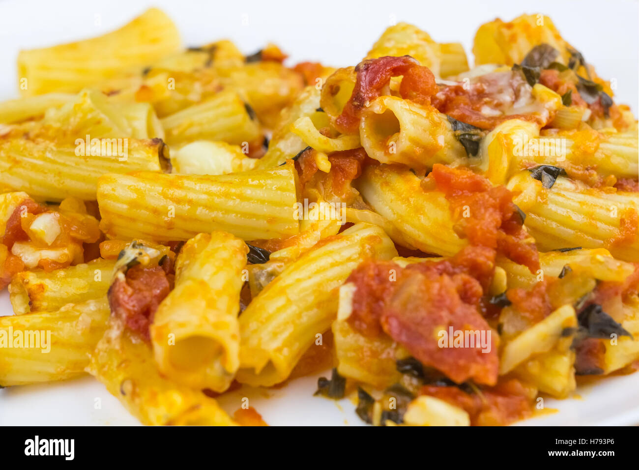 Baked tortiglioni pasta with tomato sauce, mozzarella and parmesan cheese in plate Stock Photo
