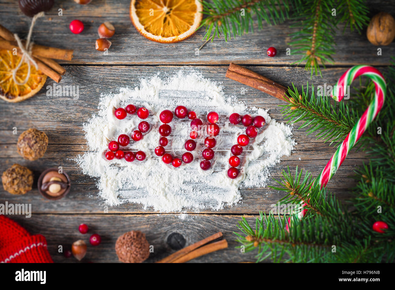 Happy New Year 2017 card ! Various candies, dried fruits, spices, fir tree and cranberries on wooden background with 2017 Stock Photo