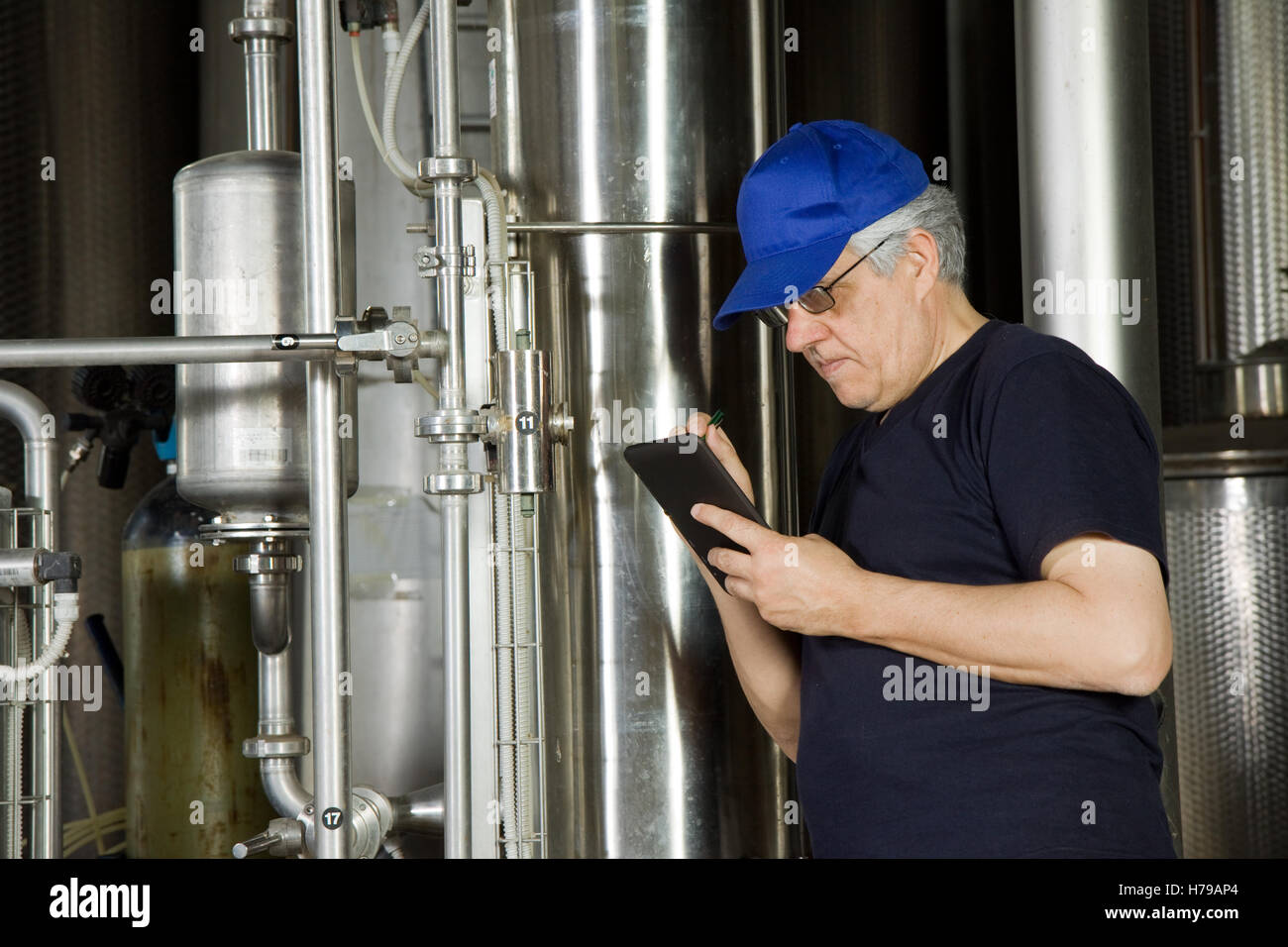 skilled worker fitting a pump plant in a industrial company Stock Photo