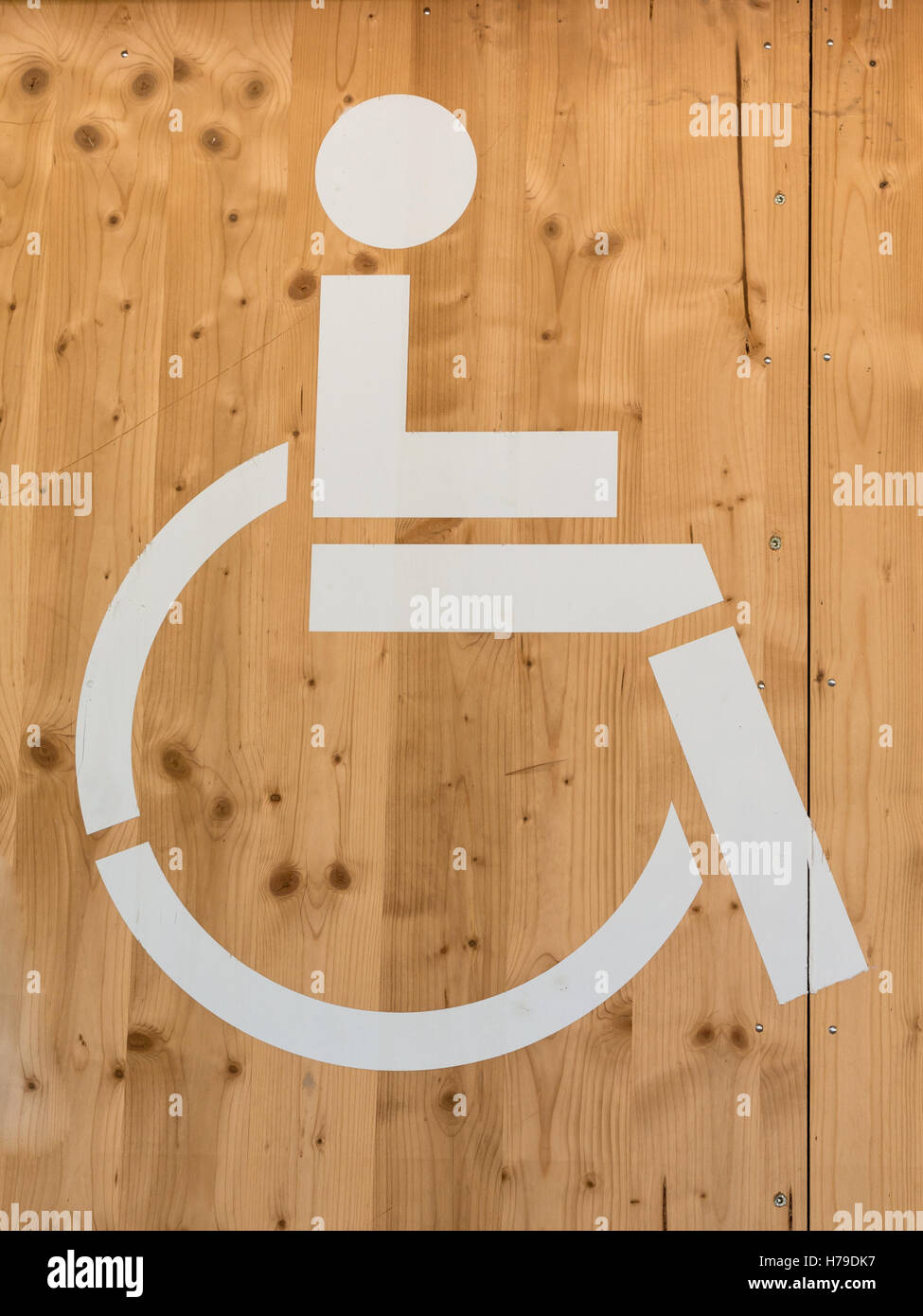 Handicap Wheelchair WC Sign: White Restroom Symbol on Wooden Background Stock Photo
