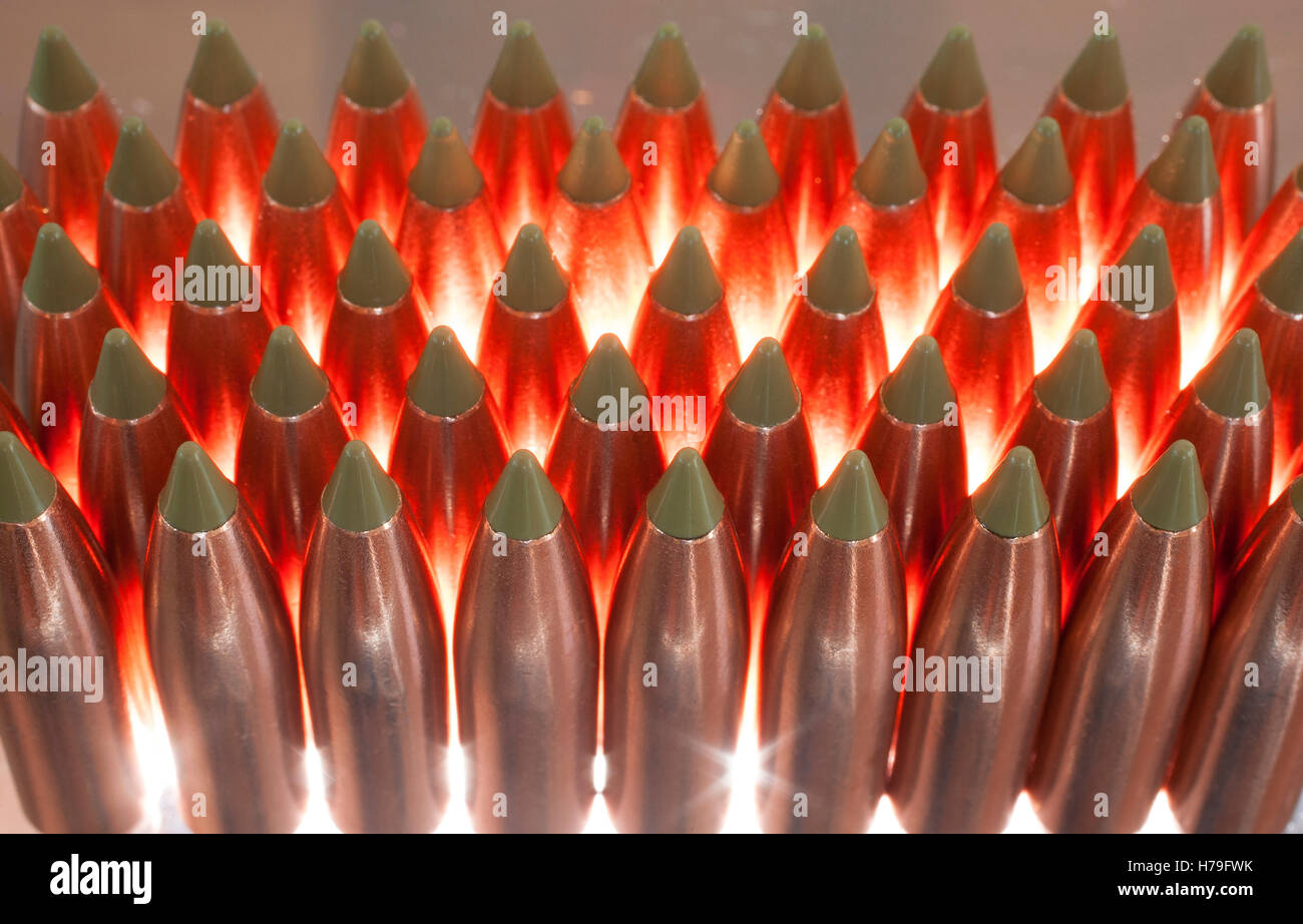 Copper bullets with a green polymer tip that are back lit Stock Photo