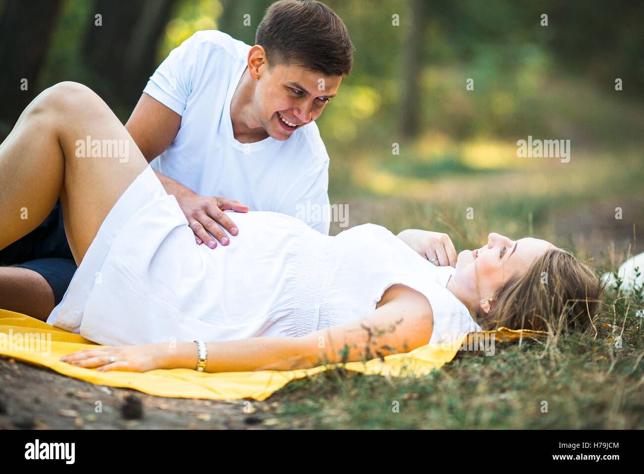 pregnant woman with husband lying in the park Stock Photo - Alamy