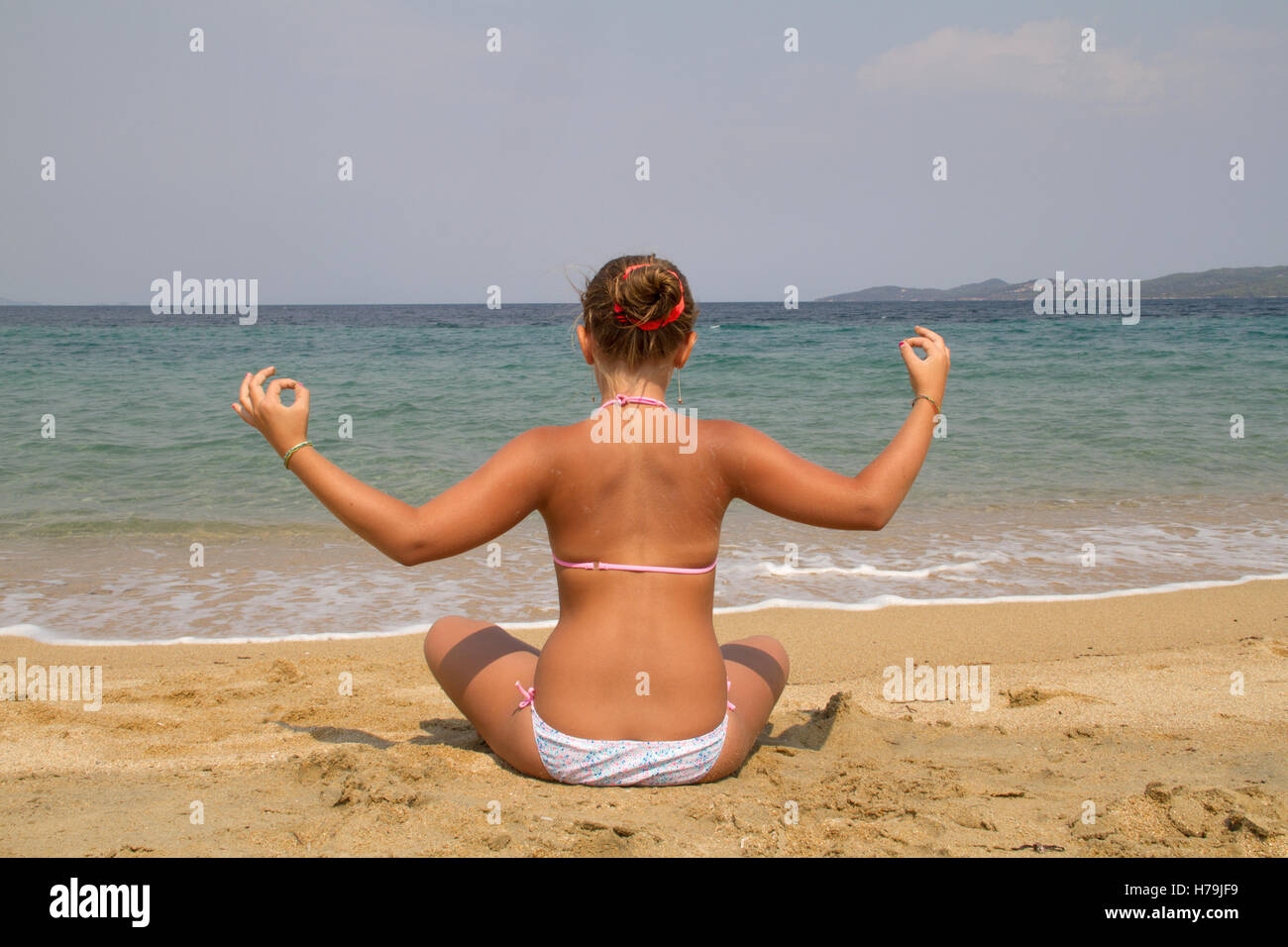 girl in yoga position on the beach Stock Photo