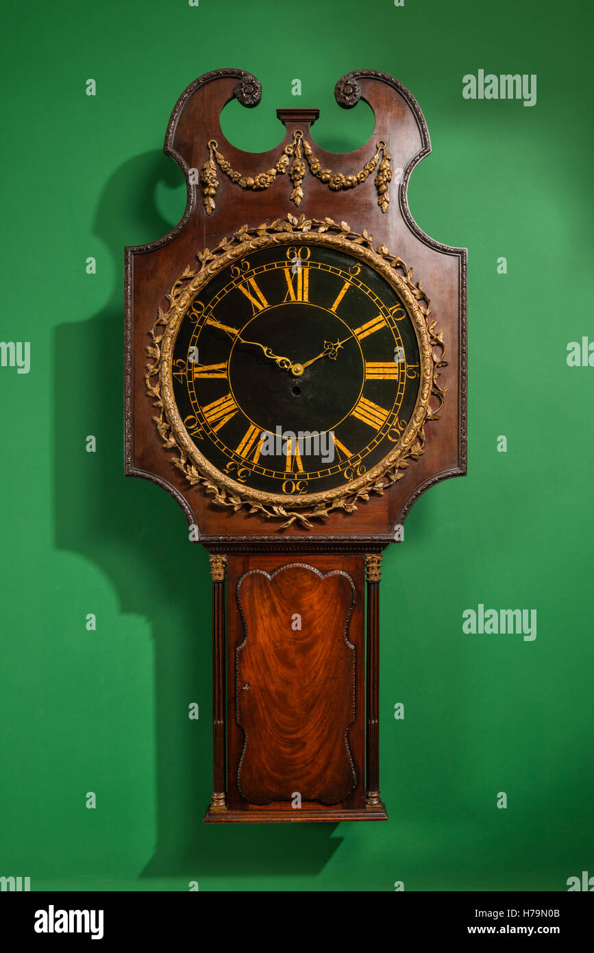 Antique wooden clock set on green wall in Dumfries house, Ayrshire, Scotland Stock Photo