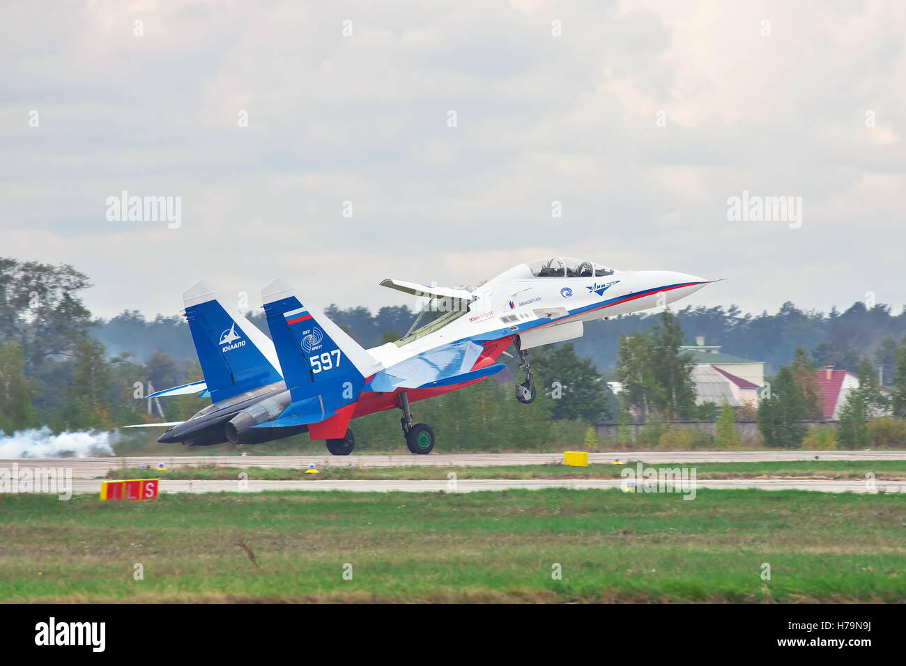 Kiev Region, Ukraine - October 2, 2010: Sukhoi Su-30LL fighter plane in Russian flag colors is landing with smoke on the runway Stock Photo