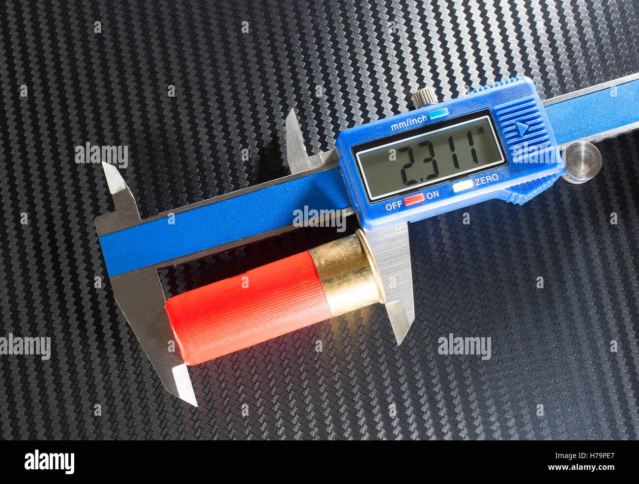 Twelve gauge shotgun shell that is being measured in a caliper Stock