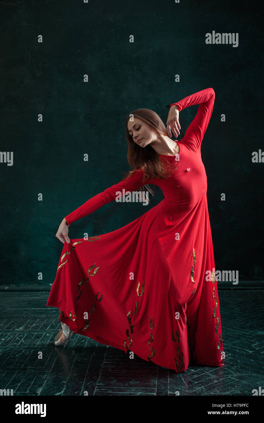 Ballerina posing in pointe shoes at black wooden pavilion Stock Photo