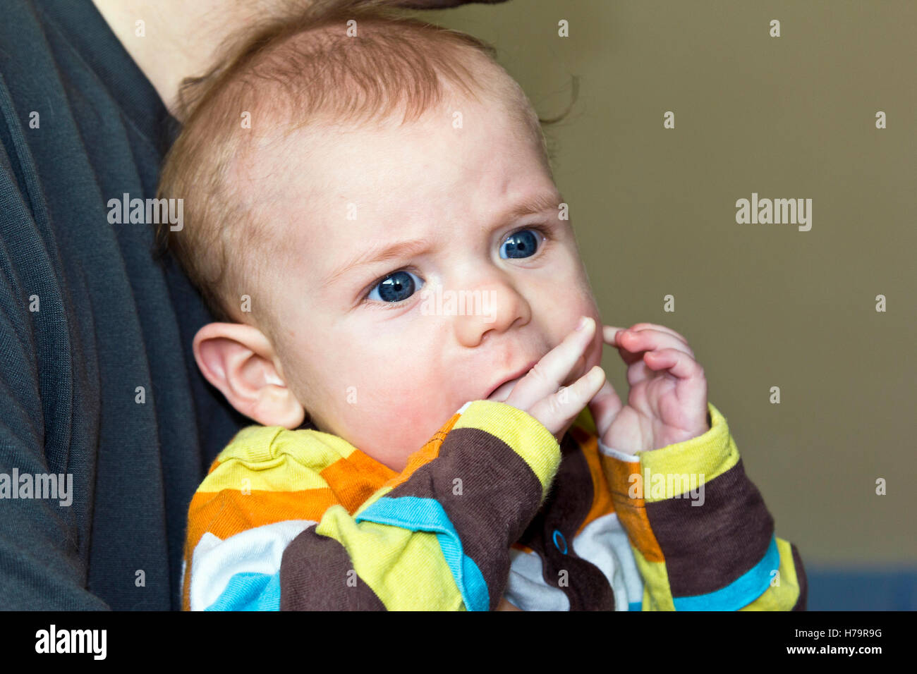Baby boy chewing his own fingers when teething Stock Photo
