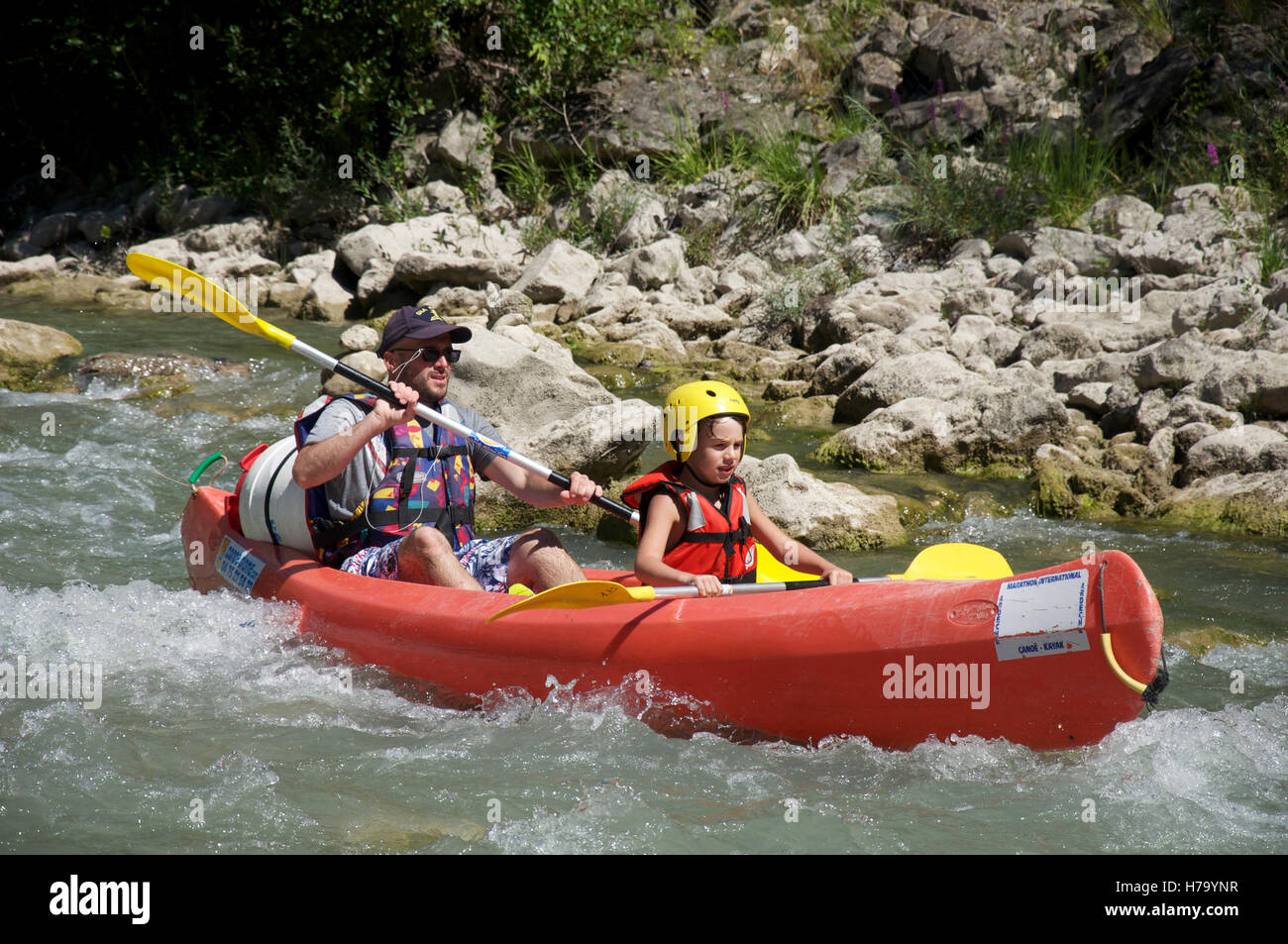 Tourism, water-sports. A father and his young son canoeing down the turbulent fast flowing waters of the Drôme River. Near Saillans, La Drôme, France. Stock Photo
