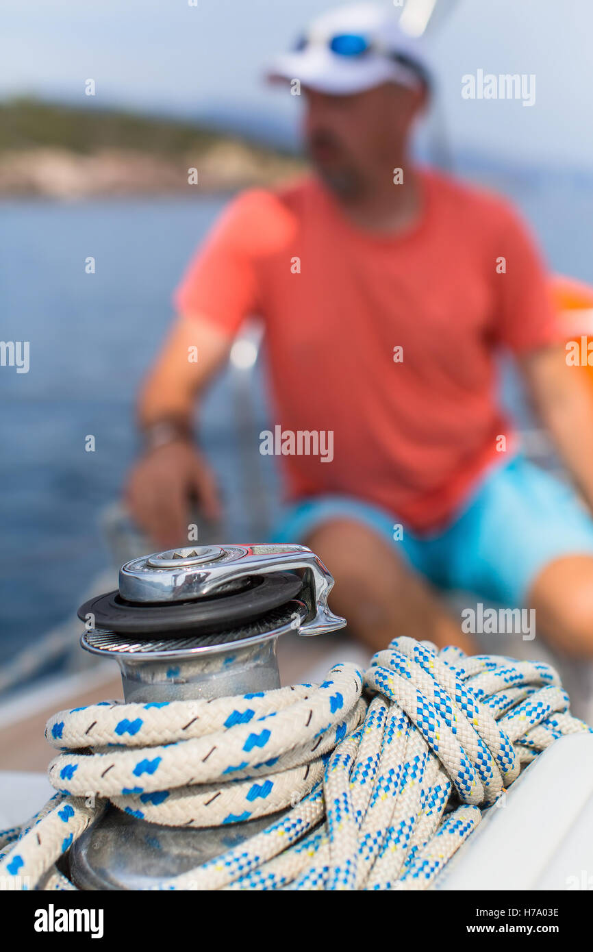 Details of yacht and rope on the sail boat, the man in the blur in the background. Stock Photo