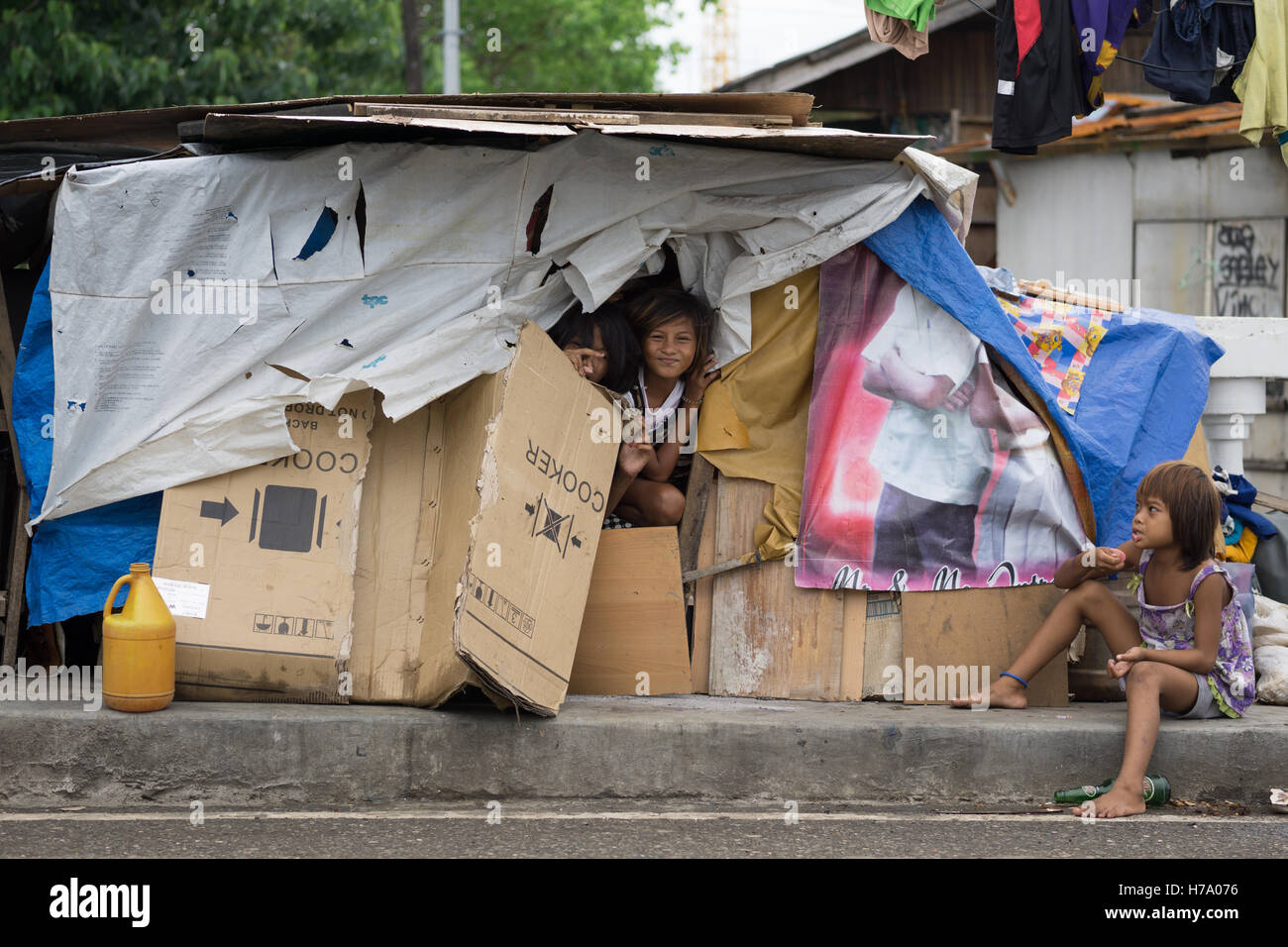 Homeless Filipino children inside a makeshift home made of cardboard,Cebu City,Philippines. Stock Photo