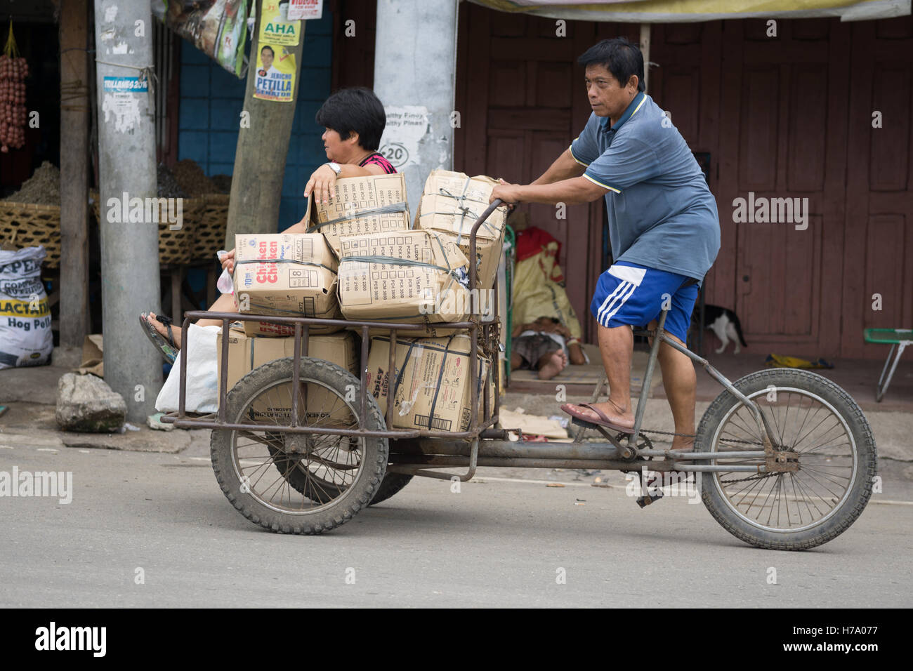 Filipino man peddling a tricycle along a street in Cebu City,Philippines. Stock Photo