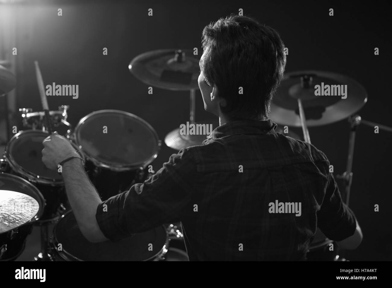 Black And White Shot Of Drummer Playing Drum Kit In Studio Stock Photo