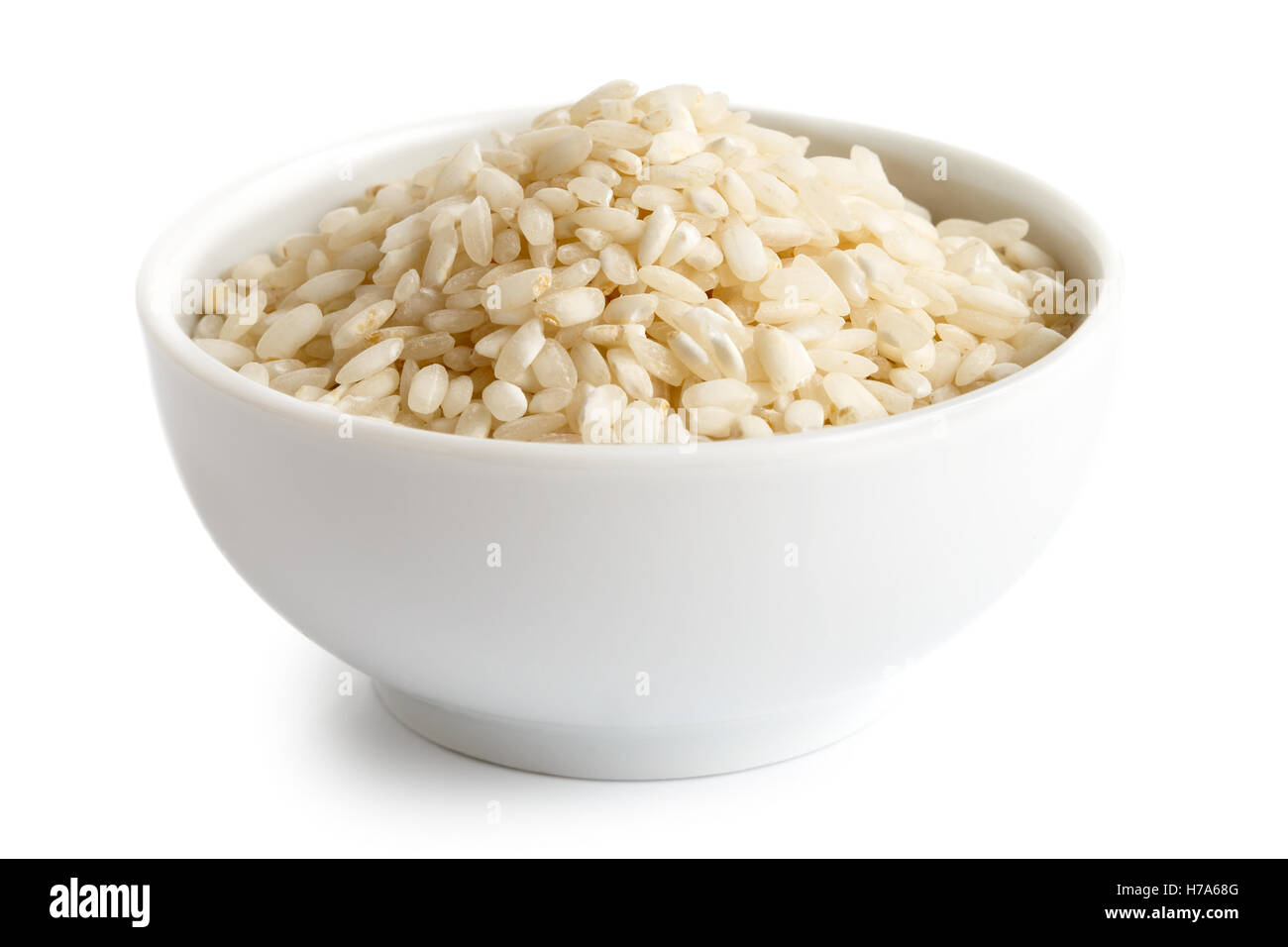 Bowl of Arborio short grain white rice isolated on white. Stock Photo