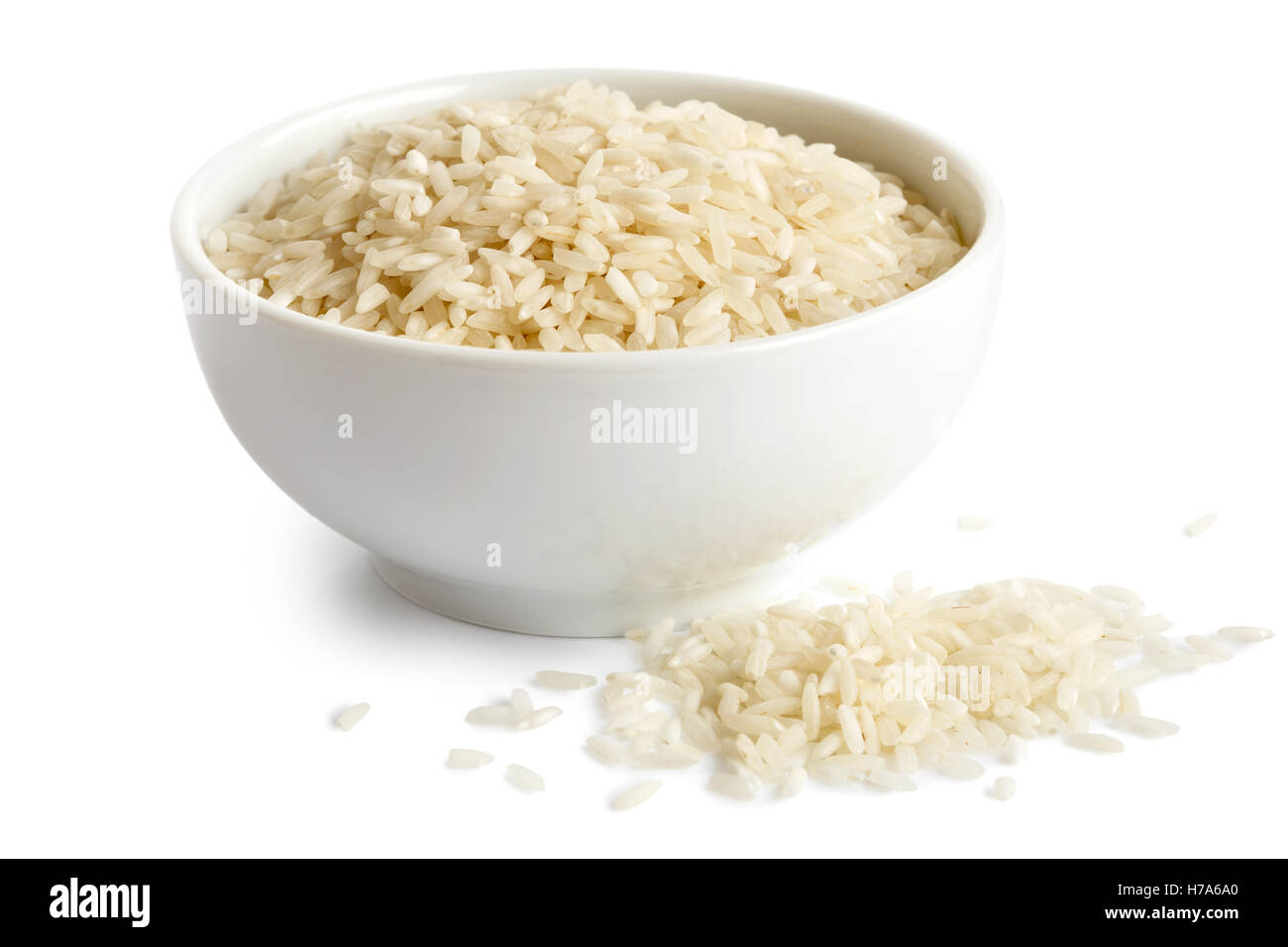 Bowl of long grain white rice isolated on white. Spilled rice. Stock Photo