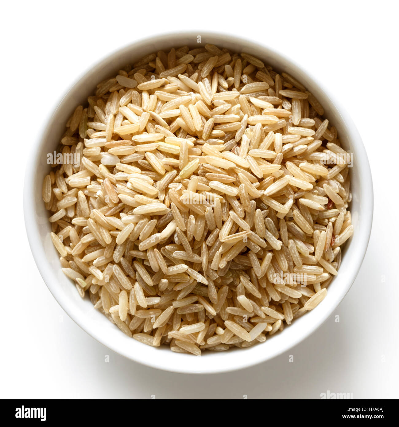 Bowl of long grain brown rice isolated on white from above. Stock Photo
