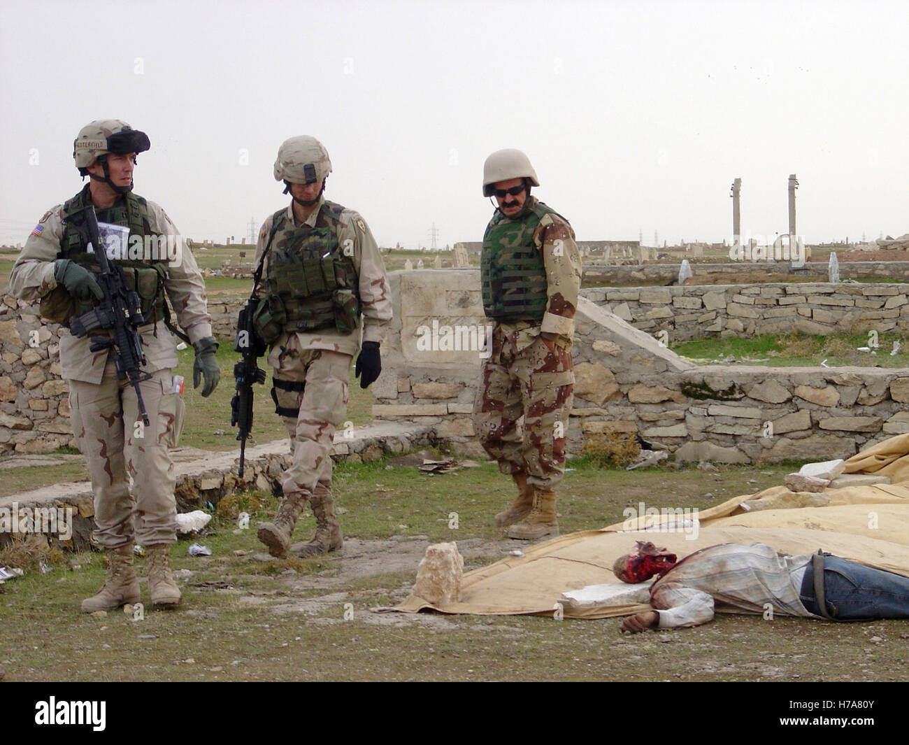26th November 2004 ING and U.S. soldiers examine a dead body, dumped by insurgents in a cemetery in Mosul, northern Iraq. Stock Photo