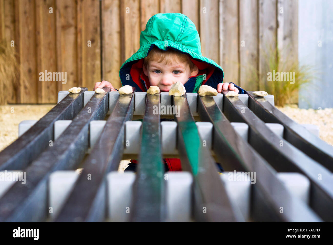 Young boy arranging stones on a bench Stock Photo