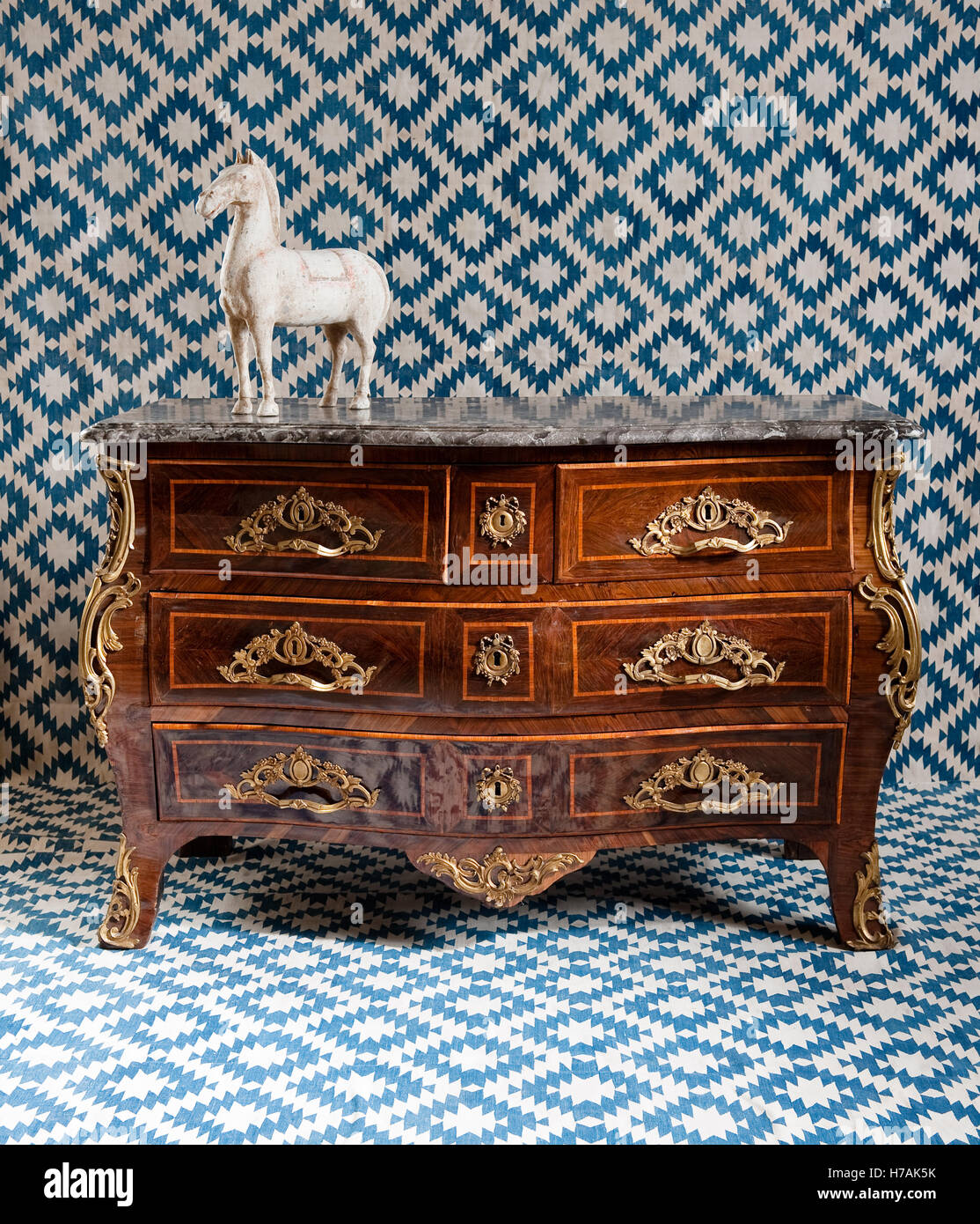 Louis XV kingwood parquetry bombe commode with ormolu mounts and grey marble. The pottery horse is Chinese Han dynasty. Stock Photo