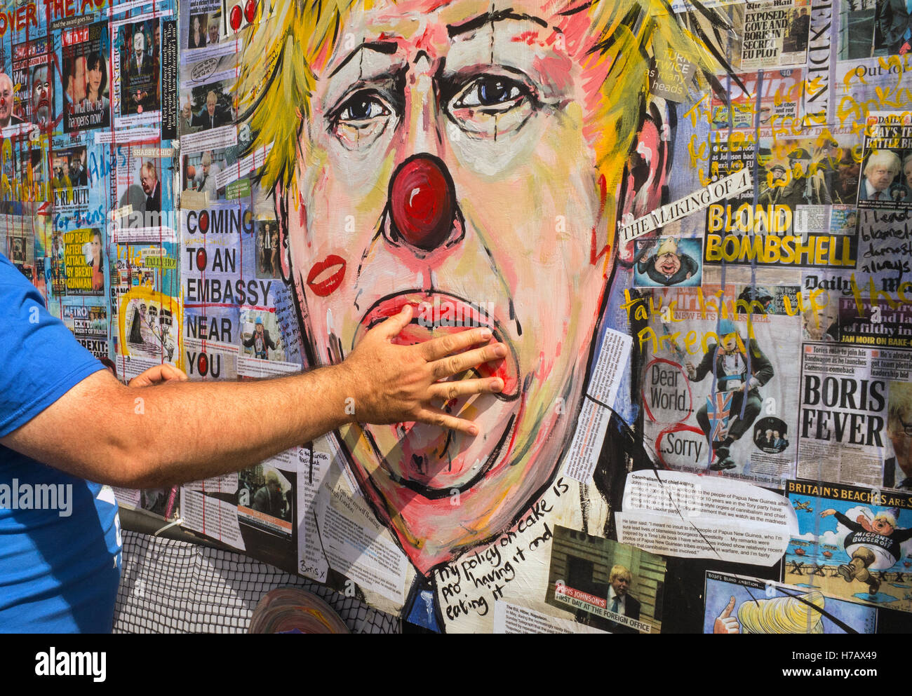A picture depicting Boris Johnson as a clown is fixed to the side of a carnival truck, with a hand placed over the mouth. Stock Photo