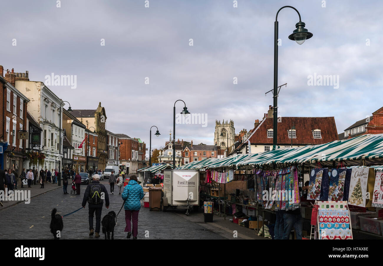 Town centre on market day with view of shops, cars, public, and St Mary's church on an overcast day in autumn. Stock Photo
