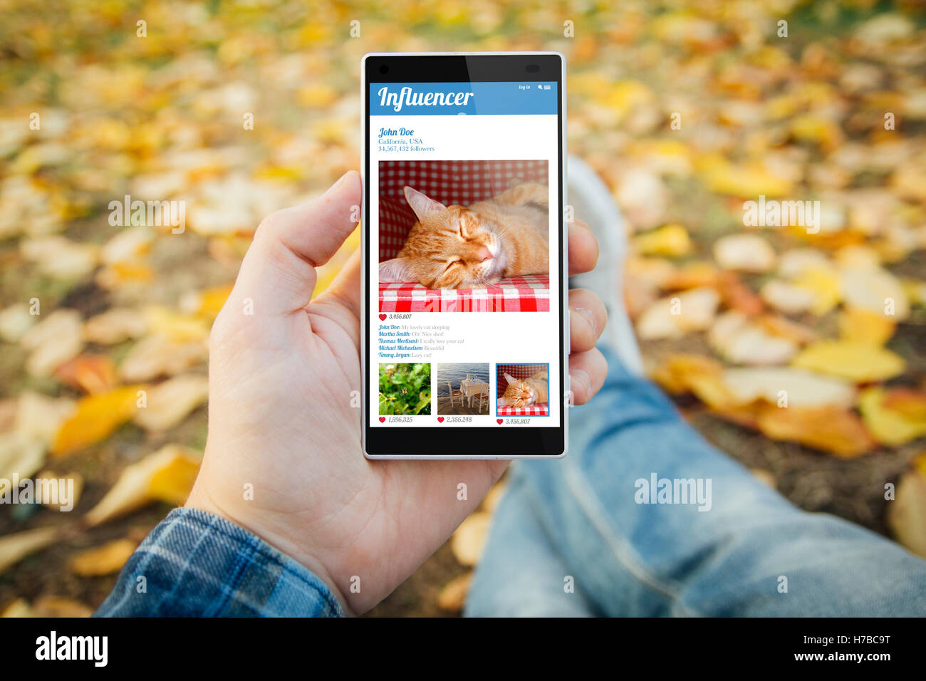 man in the park with influencer smartphone. All screen graphics are made up. Stock Photo