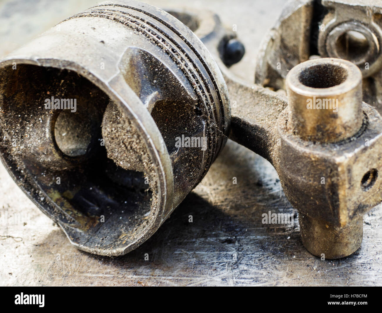 Broken and used piston on old metal background. Selective focus Stock