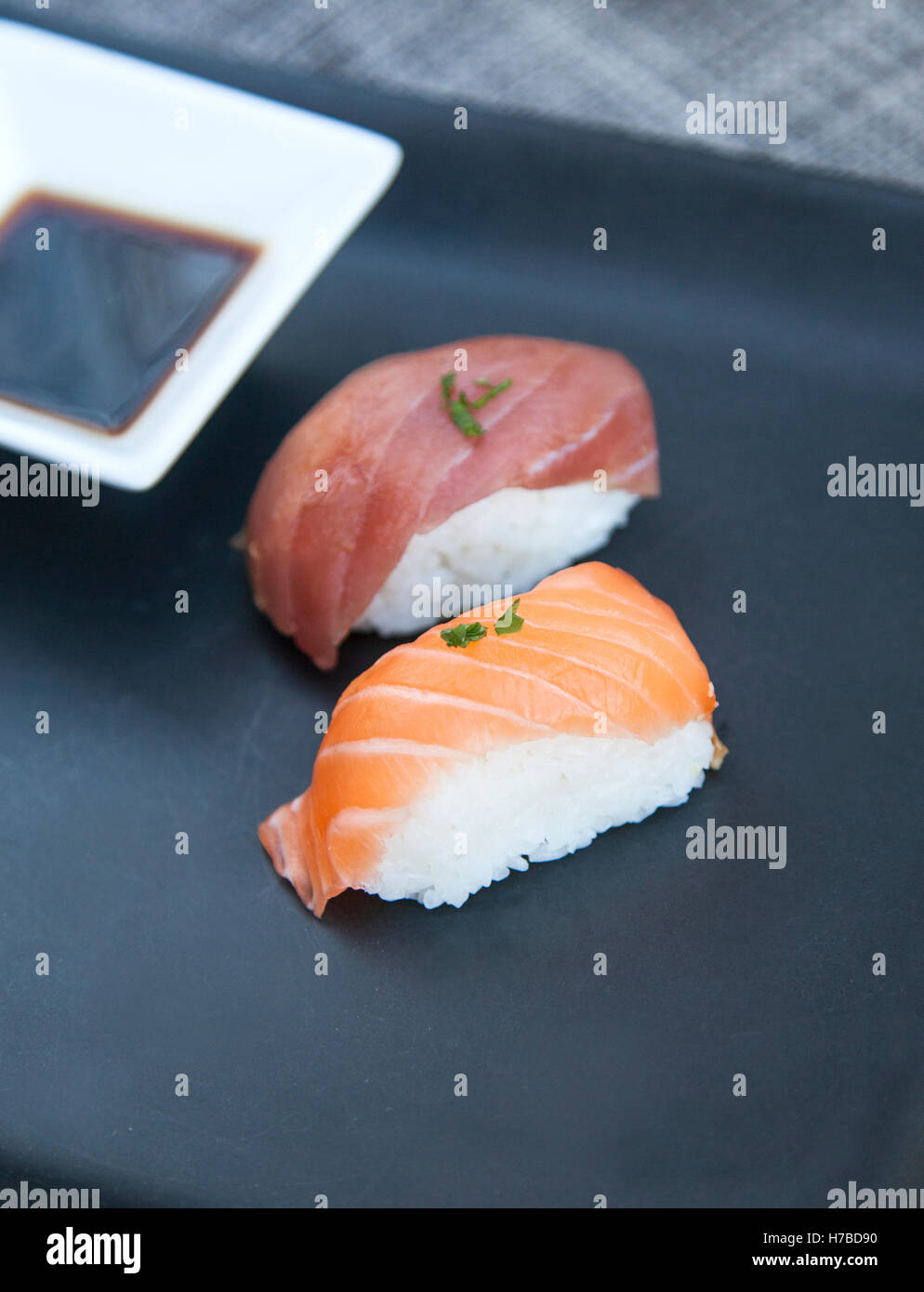 Close-up view of fresh tuna and salmon nigiri and soya sauce a dark plate Stock Photo