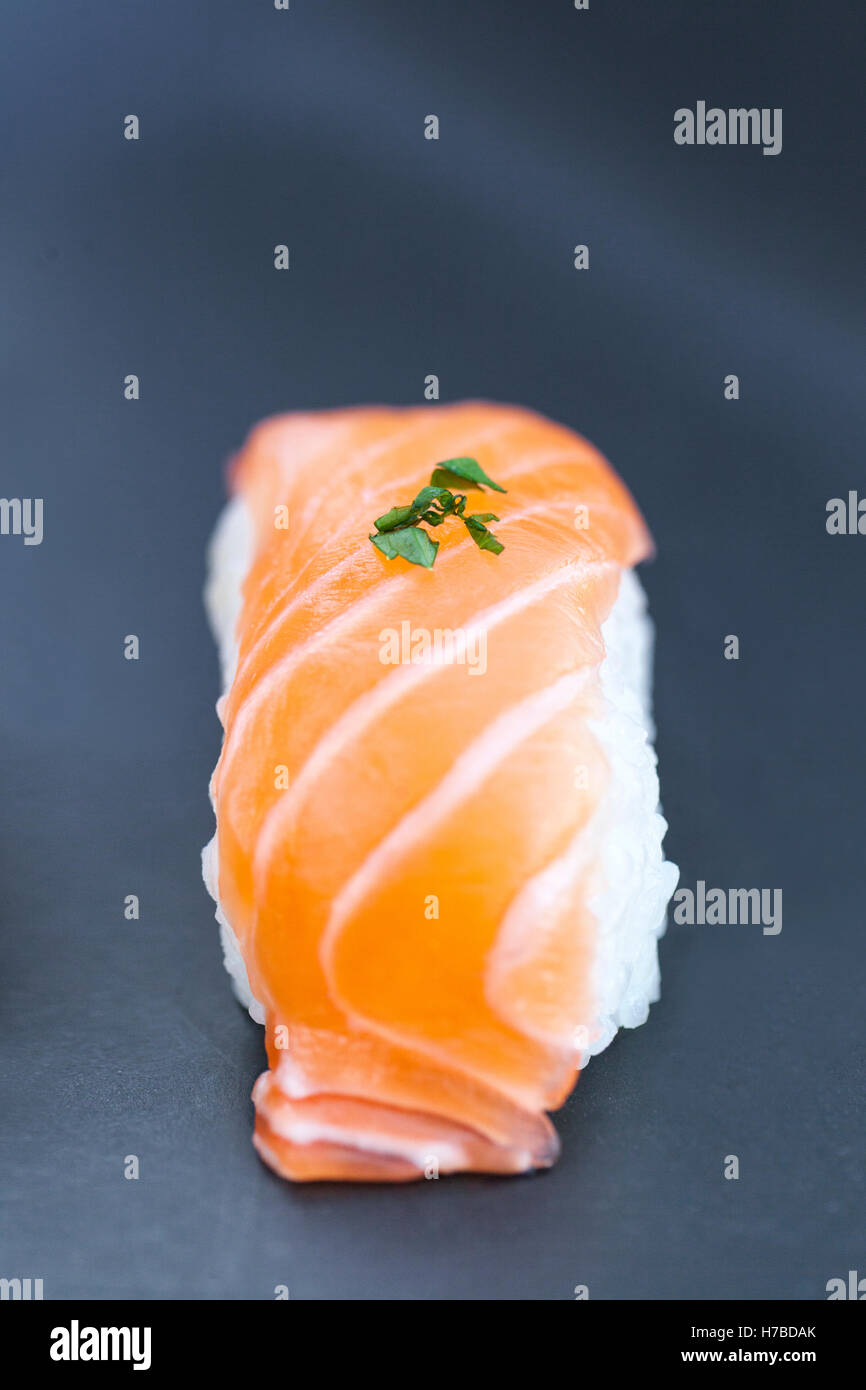 Close-up view of fresh salmon nigiri on a dark plate Stock Photo