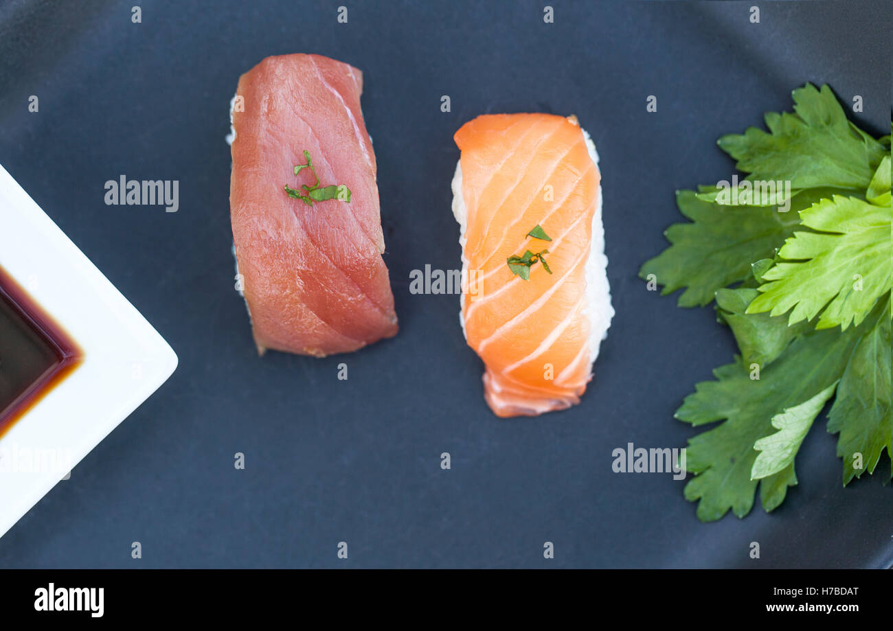 Close-up view of fresh tuna and salmon nigiri and soya sauce a dark plate Stock Photo