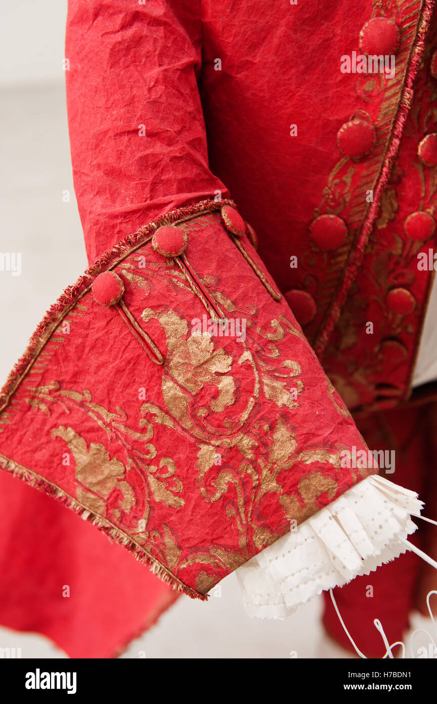 Bright red jacket and trousers with gold foliate pattern, historical replica paper garments, by Isabelle de Borchgrave Stock Photo