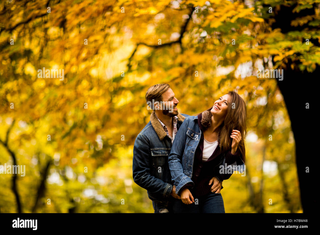 Young couple having fun in the autumn park Stock Photo - Alamy