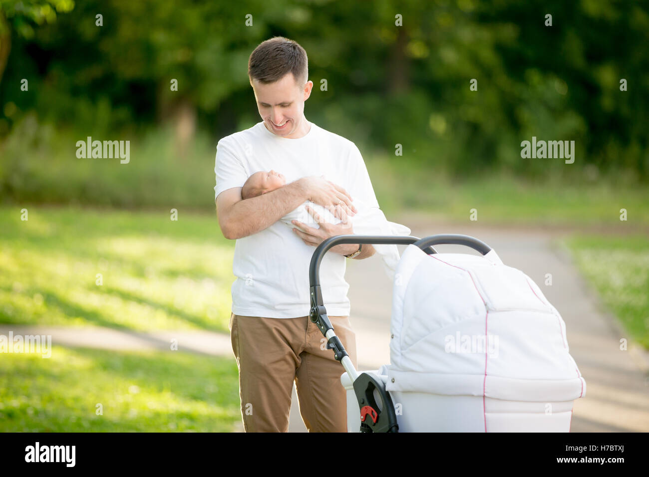 Young father holding his baby in park Stock Photo