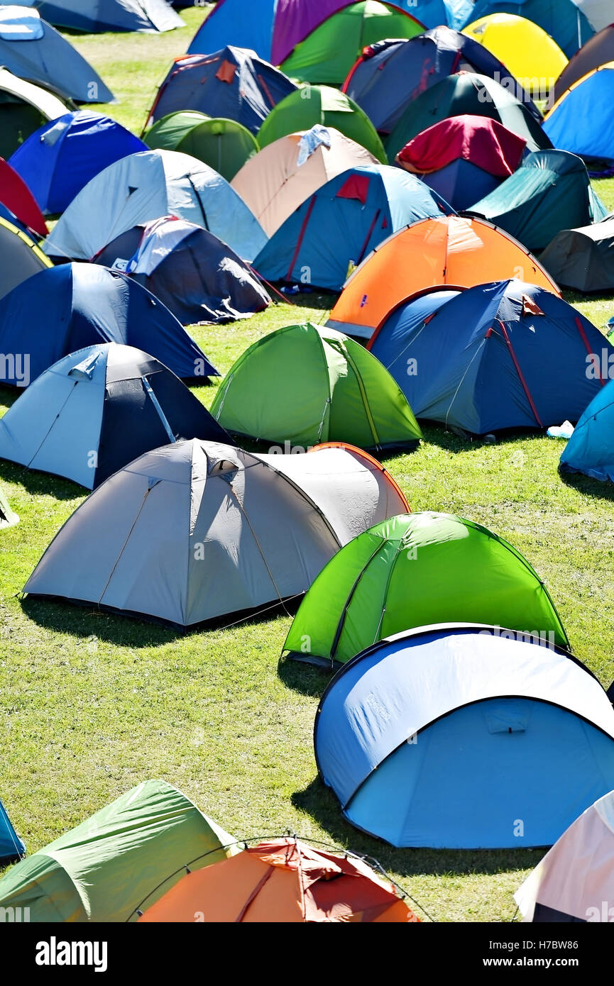 Lots of colorful tents on a meadow in a summer day during music festival Stock Photo