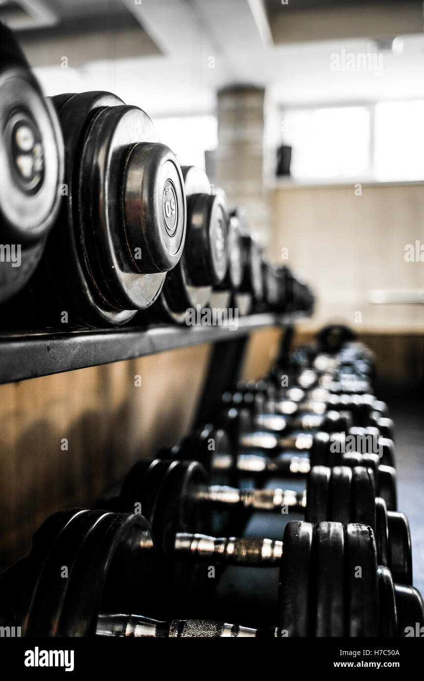Sport Background. Rack of dumbbells in health club. Shelf with metal on ...