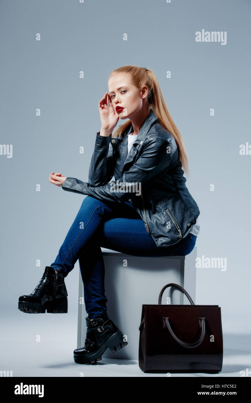 Fashion model with bag on white cube Stock Photo