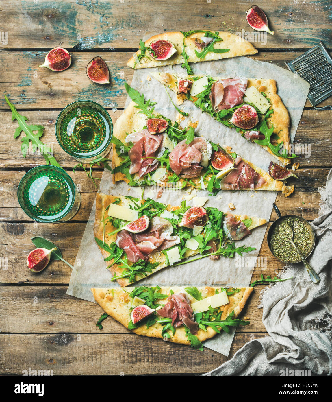 Fig, prosciutto, arugula and sage flatbread pizza cut into pieces with