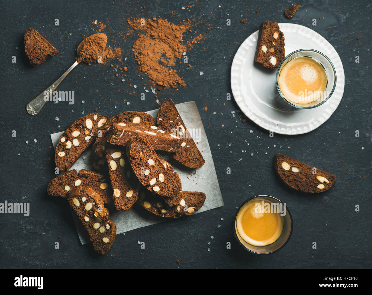 Dark chocolate and sea salt Biscotti with almonds and two glasses of coffee espresso over dark stone background, top view, selec Stock Photo