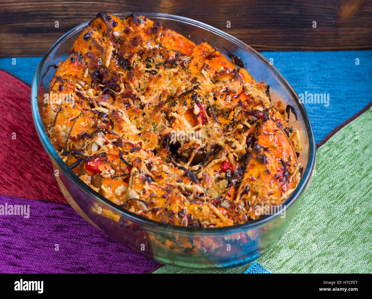 Vegetarian dish of orange pumkin, mixed vegetables, herbs and cheese baked in oven Stock Photo