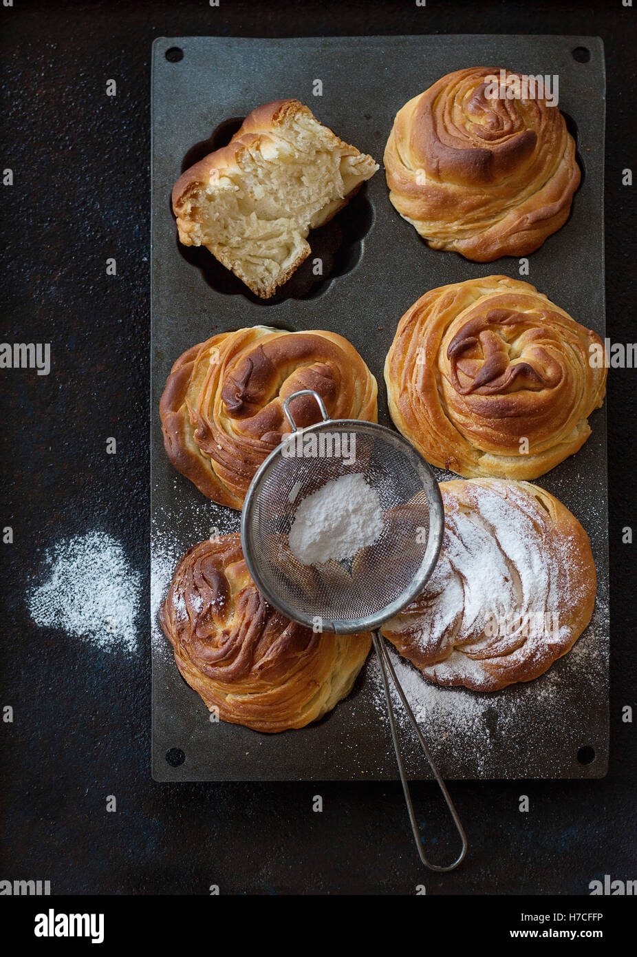 Fresh baked modern pastries cruffins, like croissant and muffin with sugar powder, served in